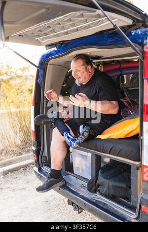 Man with prosthetic leg enjoying van life travel Stock Photo