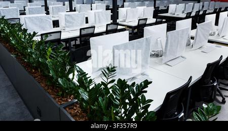 Wrapped in cover computers on workplaces with no people Stock Photo