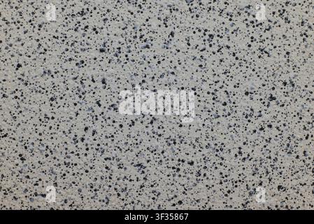 Speckled abstract wall showing uniform gray texture and black dots pattern Stock Photo