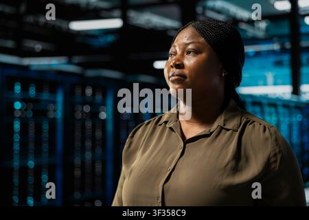 Close up of admin walking in data center with rigs supporting business needs. Server room worker doing checkup, ensuring equipment works at optimum performance for smooth operations Stock Photo