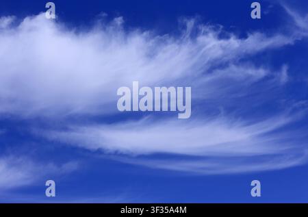 Cloudscape. Concepts - environment. Cirrus and cirrostratus clouds with a deep blue sky. Backgrounds. Copy space. Stock Photo