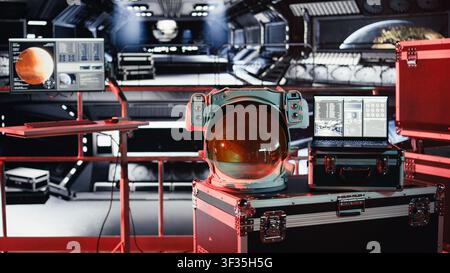 Critical error alert light flashing in spacecraft over space helmet next to laptop during journey to Mars. Malfunction hazard warning blinking over astronaut equipment during voyage to red planet Stock Photo