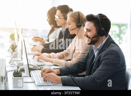 Telemarketing or hotline operators working with computers at light office Stock Photo