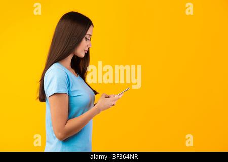 Portrait of young lady using her mobile phone, side view Stock Photo
