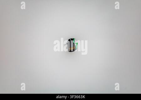 Unfinished electrical installation featuring a black light socket on a white ceiling surface Stock Photo
