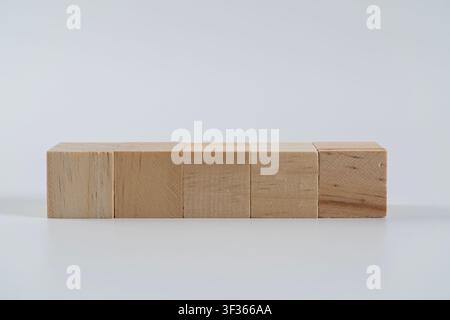 Five natural wooden cubes form a straight row, offering a clean minimalist visual for business planning, progressive steps, education, construction, a Stock Photo
