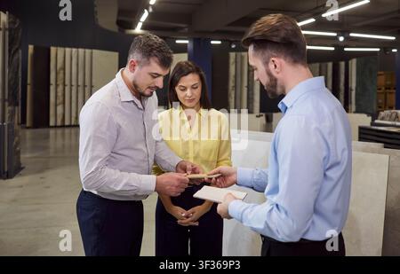 DIY store consultant helps customers choose ceramic tiles for bathroom renovation Stock Photo