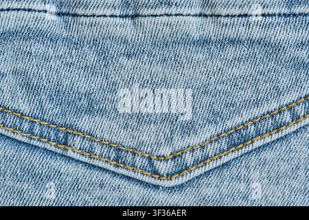 Macro texture light blue denim fabric with double yellow stitched seam on back pocket detail Stock Photo