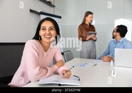 Businesswoman thinks on ideas, writing in notebook, participate in meeting Stock Photo