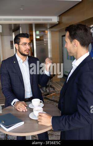 Colleagues discussing statistics data or corporate finances in conference room Stock Photo