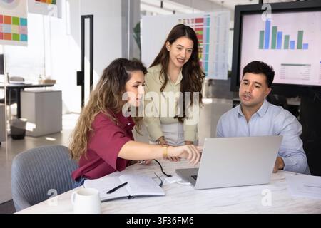 Group of diverse colleagues reviewing financial report on laptop Stock Photo