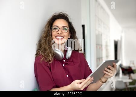 Female freelancer sitting in coworking using digital tablet, portrait Stock Photo
