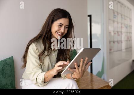 Female freelancer working on digital tablet in coworking office Stock Photo