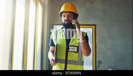 Construction, phone call and man in building for inspection, project update and talking to contractor. Engineer, supervisor and person on cellphone Stock Photo