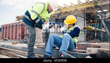 Construction, men and help with arm injury for scaffolding accident, building hazard or fracture. Site first aid, workers and assistance for muscle Stock Photo