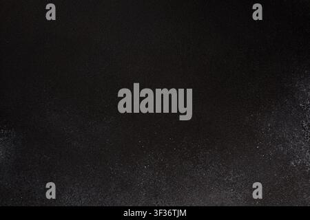 Dark black textured background with subtle vertical gradient and white dust speckles concentrated at the bottom, elegant luxury backdrop with copy spa Stock Photo