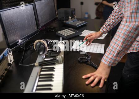 Music producer adjusting mixing controls in recording studio Stock Photo