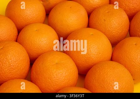 Many whole oranges pile. Clementine fruits background, fresh citrus big group on market, mandarin heap in supermarket Stock Photo
