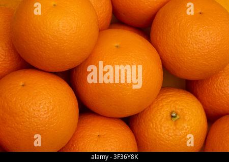 Many whole oranges pile. Clementine fruits background, fresh citrus big group on market, mandarin heap in supermarket Stock Photo