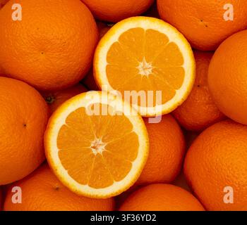 Many whole oranges pile. Clementine fruits background, fresh citrus big group on market, mandarin heap in supermarket Stock Photo
