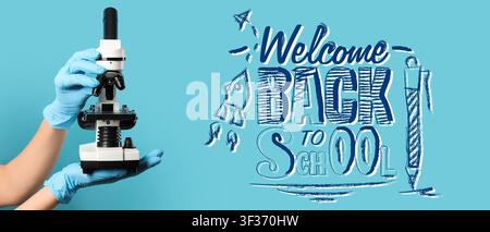 Student hands in blue gloves holding a microscope with welcome back to school text and rocket drawing on a blue background Stock Photo