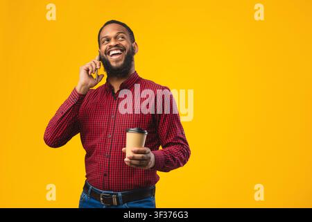 Smiling black guy talking on the phone at studio Stock Photo