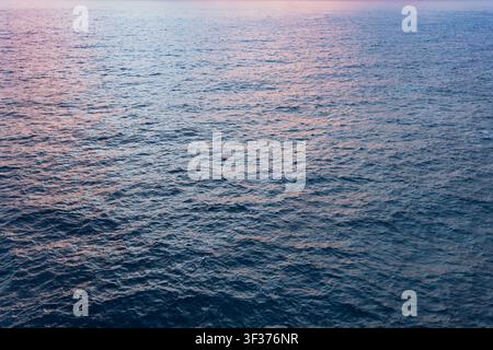Gentle waves ocean surface reflecting the soft hues of twilight dusk tranquil expanse of the water subtle ripples during evening twilight time Stock Photo