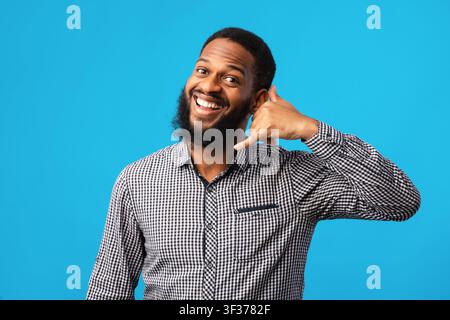 Afro man doing phone gesture at studio Stock Photo
