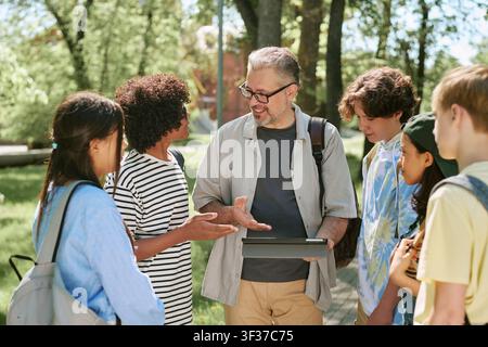 Diverse Teen Students Studying with Teacher in Outdoor Class Stock Photo