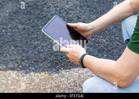 Close up of man's hands holding digital tablet during outdoor  inspection of construction aggregate stockpiles. Concept of construction inspection, di Stock Photo