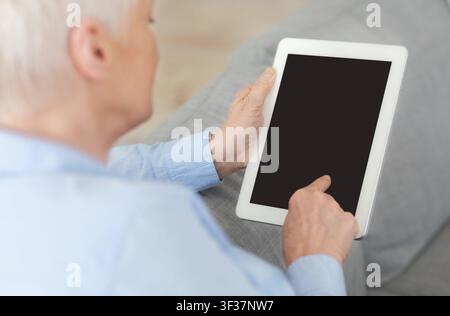 Unrecognizable Senior Woman Using Digital Tablet With Blank Screen At Home, Mockup Stock Photo