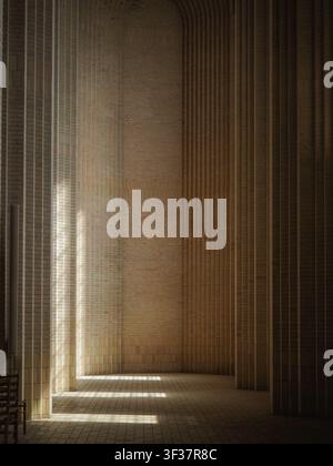 Sunlight casting bright geometric shadows across a textured yellow brick wall and tiled floor inside Grundtvig's Church in Copenhagen, Denmark. Stock Photo