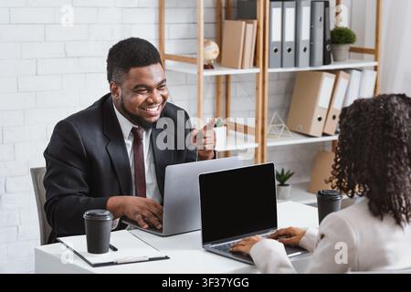 Teamwork and collaboration. Smiling colleagues having friendly communication at workplace Stock Photo