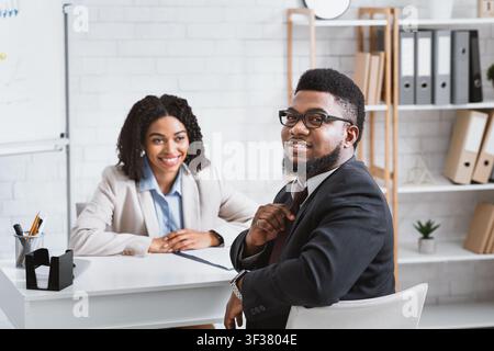 Cheerful African American guy having job interview with hiring manager at company office Stock Photo
