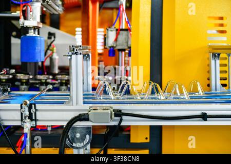 Automated conveyor belt moving clear  dome cup lids in food packaging factory Stock Photo