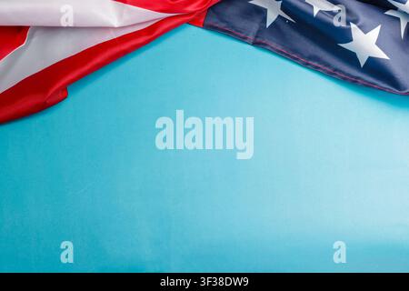 Top frame featuring the American flag draped on a bright blue background with copy space. High Quality Photo Stock Photo