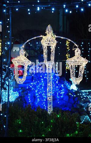 Outdoor LED figure in the form of a vintage triple street lamp, used for New Year's illumination. High quality photo Stock Photo