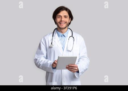 Cheerful doctor using digital tablet in hands Stock Photo