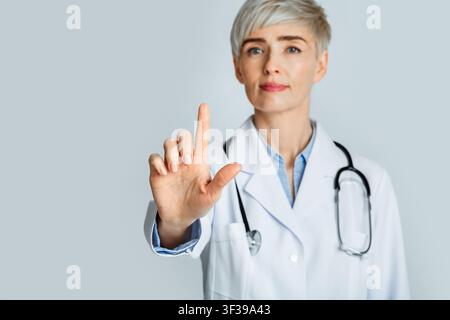 Technology for medical purposes. Doctor using invisible touchscreen and pressing key Stock Photo