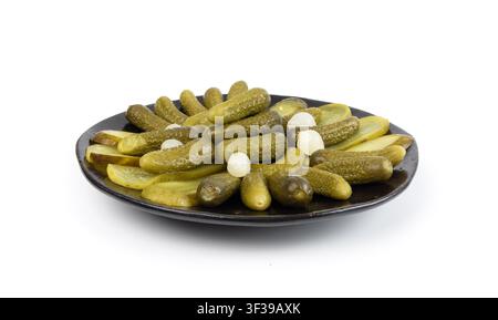 Pickled sliced cucumbers on black plate isolated. fermented food, marinated canned vegetables, gherkins, pickled cucumbers on white background side vi Stock Photo