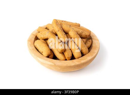 Small breadsticks, short grissini or picos with fragrant herbs and seeds in wood bowl isolated. Crispy mini bread sticks on white background Stock Photo