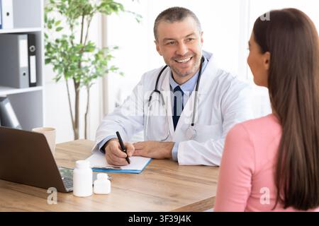 Male experienced doctor talking to his female patient Stock Photo