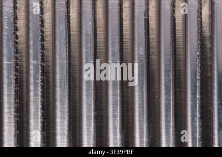 Macro texture ribbed silver metal surface with vertical shiny aluminum lines and shadows Stock Photo