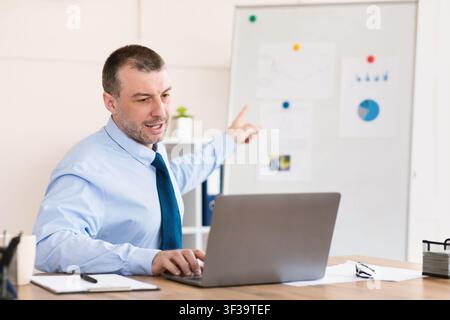 Businessman Using Laptop Making Video Conference Presentation Sitting In Office Stock Photo