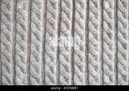 Close-up of grey cable knit sweater texture showing soft wool pattern and cozy winter fabric Stock Photo