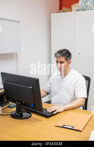 Doctor working on computer in orthopedic clinic Stock Photo