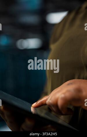 Close up of data center admin using tablet to troubleshoot backend operations hardware handling user requests. Server farm IT professional running software development app, resolving system crashes Stock Photo