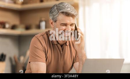 Happy Senior Caucasian Man Talking On Phone While Working At Home Office, Business Concept Stock Photo