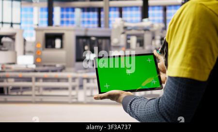 Solar panels plant technician uses green screen tablet to oversee systems. Photovoltaics plant employee uses software on chroma key device to maintain operations, camera A close up Stock Photo