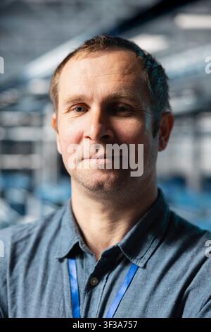 Close up portrait of data center technician analyzing supercomputers performance, resolving hardware failures. Server farm IT specialist doing job tasks, overseeing operations Stock Photo